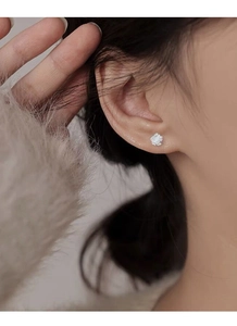 Detailed close-up of S925 silver camellia flower stud earrings with white pearl luster