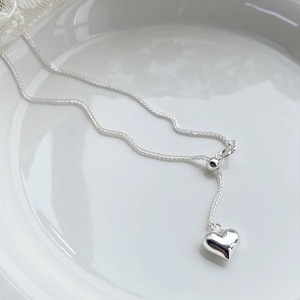 Minimalist S925 sterling silver heart necklace on white ceramic plate background