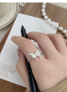 Detailed view of sterling silver butterfly ring with cubic zirconia worn on hand