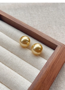 Macro shot of twin S925 silver golden round pearls with metallic mirror luster on display
