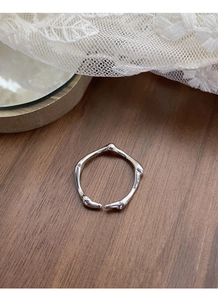 Macro shot of S925 sterling silver irregular texture ring on dark walnut wood background