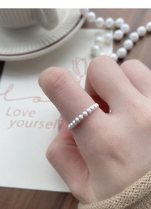 Close-up of S925 sterling silver beaded ring with frosted matte finish on wooden table