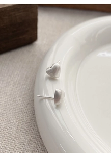 Vue détaillée des boucles d'oreilles cœur en argent S925 avec finition mate et brossée