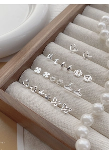 Macro shot of assorted S999 silver stud earrings with heart and floral motifs