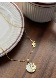 Détail du collier en argent S925 doré avec pendentif en nacre et symbole Fu chinois