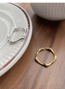 Detailed view of silver and gold irregular texture open rings on a vintage plate