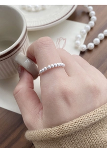 Detail of S925 sterling silver frosted beaded ring worn on the index finger