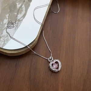 S925 silver heart necklace with pink stone and white diamonds on dark wood surface