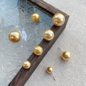 Elegant gold pearl studs in various sizes on a vintage glass tray, minimalist S925 style