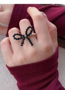 Detailed shot of an S925 silver butterfly ring with black faceted beads on a stretch cord