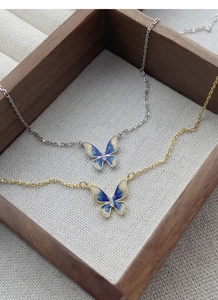 Detailed view of gold and silver S925 butterfly necklaces with blue enamel and zircon inlay