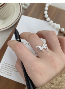 Detail of 925 sterling silver butterfly ring with cubic zirconia on a female finger