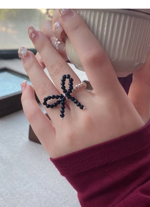 Close-up of handmade elastic S925 silver beaded ring with black crystal butterfly design