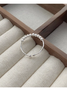Macro detail of S925 sterling silver frosted beads on a minimalist open band ring