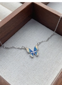 Detailed close-up of S925 silver butterfly necklace with blue enamel and sparkling zircons