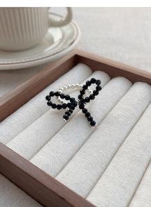 Close-up of a handmade S925 silver beaded ring with a black crystal butterfly bow