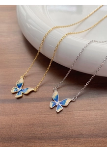 Detailed macro view of S925 enamel butterfly pendants in gold and silver finishes