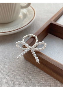 Close-up of S925 silver beaded ring with white pearls and handcrafted bow design