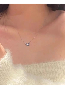 Close-up of S925 silver necklace featuring a blue enamel butterfly pendant on a model
