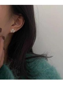 Close-up of S925 sterling silver firework earrings worn on ear with polished finish