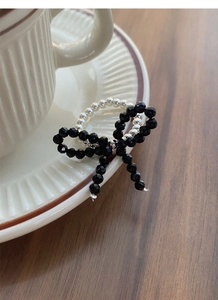 Detailed macro view of S925 silver beaded ring with handmade black crystal butterfly design