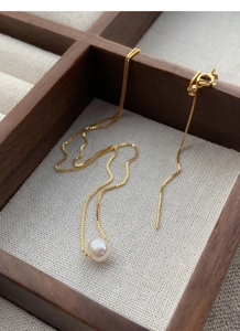 Detail of S925 sterling silver gold-plated box chain with a white freshwater pearl charm