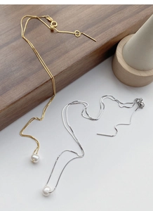 Detailed macro view of S925 silver and gold box chains with round freshwater pearls