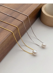 Detail view of single freshwater pearl pendants on gold and silver box chains