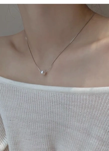 Close-up of a minimalist S925 silver necklace featuring a round white freshwater pearl