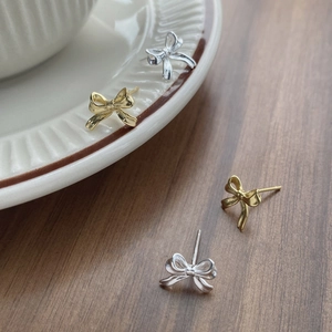 Élégantes boucles d'oreilles nœud papillon en argent S999, finitions dorée et argentée sur plat