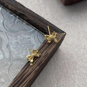 Boucles d'oreilles nœud papillon en argent fin S999 au fini doré élégant
