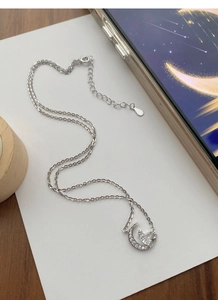 Détail du collier lune en argent S925 avec zircon en forme de cœur et finitions étoiles