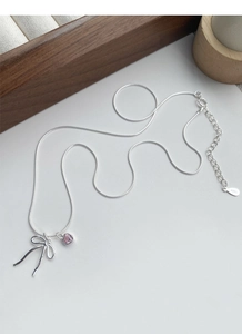 Detail of S925 silver necklace with pink heart gem and delicate bow pendant