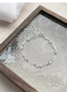 Macro detail of S925 sterling silver bracelet showing leaf-shaped links and zircon stones