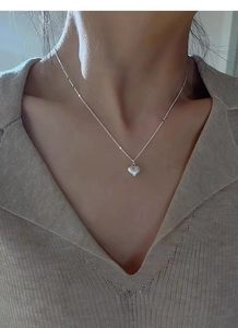 Macro shot of S925 sterling silver heart necklace with a brushed matte finish detail