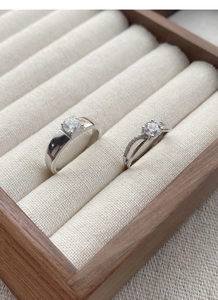 Close-up of S925 sterling silver couple rings with brilliant zircons in a wooden box