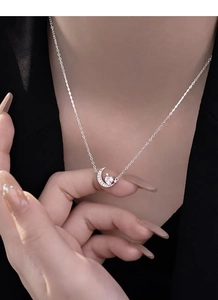 Gros plan du collier lune en argent S925 avec pendentif diamant coeur porté au cou