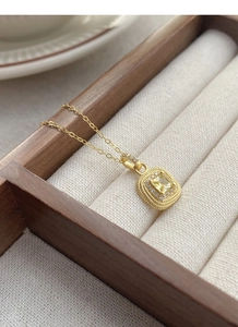 Close-up of a gold S925 sterling silver necklace featuring a square yellow gemstone pendant