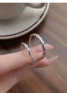 Detail of S925 silver Mobius rings with twisted band and cubic zirconia on female hand