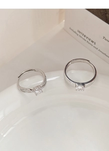 Close-up of S925 sterling silver couple rings with sparkling zircon pavé on a white plate