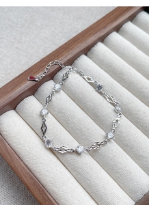 Detailed macro view of S925 silver bracelet featuring circular zircons and textured diamond links