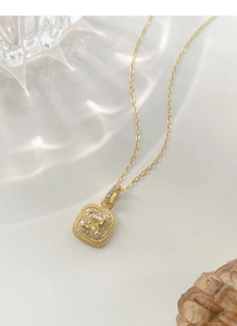 Macro shot of S925 silver gold necklace featuring a yellow square gemstone pendant