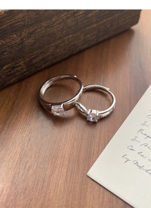 Close-up of S925 sterling silver couple rings with cubic zirconia on a wooden surface