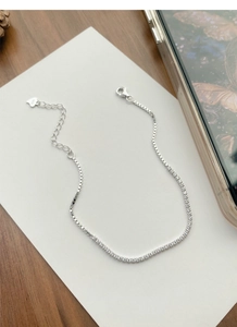 Detail of S925 sterling silver bracelet showing tennis chain links and heart charm