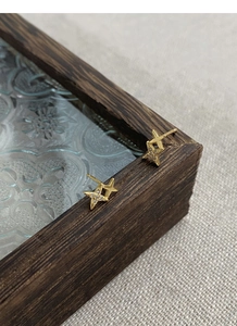 Close-up of gold star earrings with pavé zircon accents on vintage wooden background
