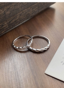 Macro shot of S925 sterling silver Mobius couple rings with twisted texture detail