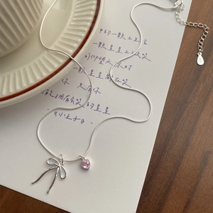 S925 silver necklace with pink heart zircon and bow pendant on a poetic background