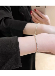 Detail view of two gold-plated S925 silver tennis bracelets with sparkling white cubic zirconia