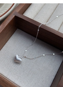 Macro shot of S925 sterling silver heart pendant with brushed matte texture in a jewelry box