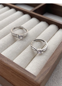 Close-up of S925 silver couple rings with cubic zirconia in a premium wood jewelry box